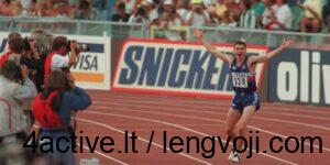 edwards_in-750x375 - 4Active - 4Active Sprinter in blue raises arms in victory as photographers line the track’s left side and spectators cheer in the background.